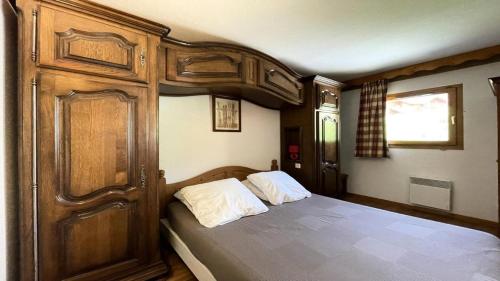 une chambre avec un lit avec une armoire en bois dans l'établissement Résidence Dame Blanche - DBA329 - APPT 1 CHAMBRE + CABINE - BALCON - 6 PERSONNES MAE-7974, à Narreyroux