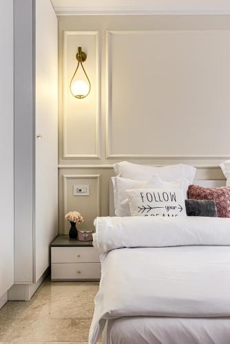 a bedroom with a bed with white sheets and a lamp at Sika DeLuxe Apartment Arad in Arad