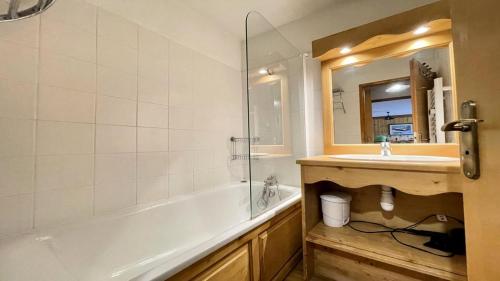 une salle de bain avec une baignoire, un lavabo et un miroir dans l'établissement Résidence Dame Blanche - DBAC24 - APPT DUPLEX DANS CHALET - 4 CHAMBRES 10 PERSONNES - Secteur 1800 MAE-7984, à Narreyroux