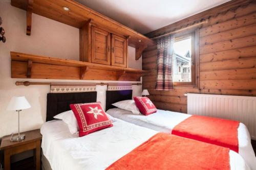 deux lits dans une chambre aux murs en bois dans l'établissement Résidence La Ginabelle - maeva Home - Appartement 3 pièces 6 personnes - Prestige MAE-3904, à Chamonix-Mont-Blanc