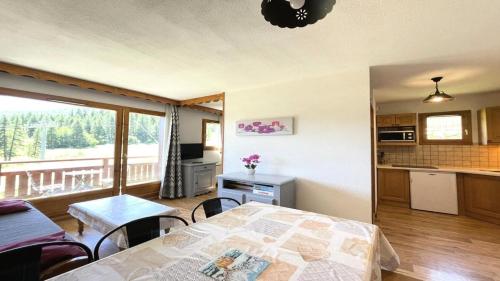 a bedroom with a bed and a kitchen with a balcony at Résidence Dame Blanche - 3 Pièces pour 6 Personnes 664 in Narreyroux