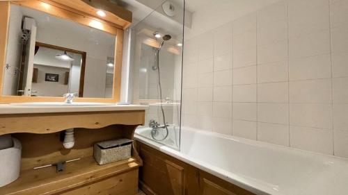 a bathroom with a tub and a sink and a mirror at Résidence Dame Blanche - 2 Pièces pour 6 Personnes 994 in Narreyroux