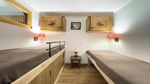 a bedroom with two beds and wooden cabinets at Résidence Dame Blanche - 2 Pièces pour 6 Personnes 994 in Narreyroux