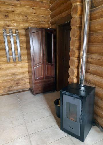 a fireplace in a room with a wooden wall at къщи за гости Под звездите in Pamporovo