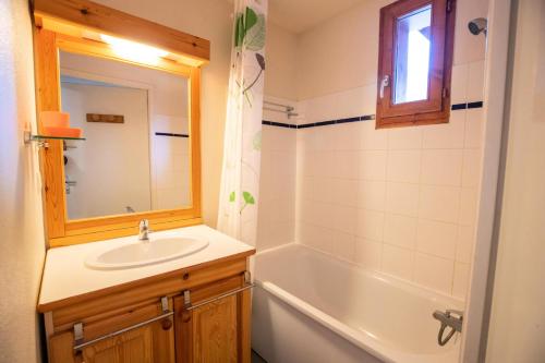 uma casa de banho com um lavatório e uma banheira em Chalet Arrondaz J - 3 Pièces pour 6 Personnes 193111 em Modane