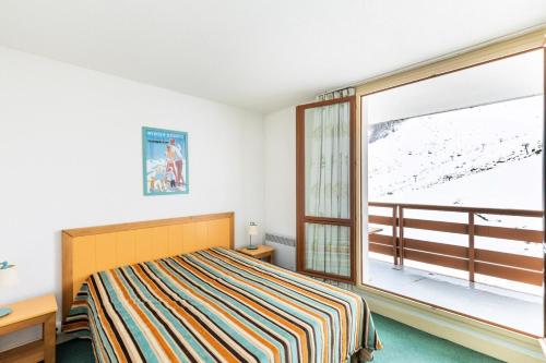 une chambre avec un lit et une grande fenêtre dans l'établissement Résidence Le Montana - maeva Home - Appartement 2 pièces 8 personnes - Sélection MAE-7254, à La Mongie