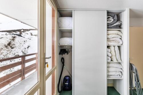 un placard avec une porte ouverte et des serviettes. dans l'établissement Résidence Le Montana - maeva Home - Appartement 2 pièces 8 personnes - Sélection MAE-7254, à La Mongie