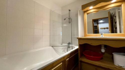 a bathroom with a tub and a sink and a mirror at Résidence Dame Blanche - Chalets pour 6 Personnes 054 in Narreyroux