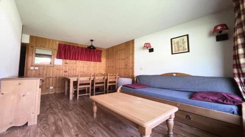 a living room with a blue couch and a table at Résidence Dame Blanche - 2 Pièces pour 6 Personnes 034 in Narreyroux