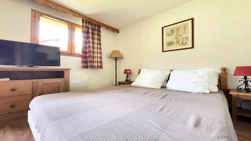 a bedroom with a large bed with a flat screen tv at Résidence Dame Blanche - 2 Pièces pour 6 Personnes 034 in Narreyroux