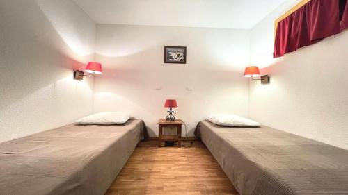 deux lits dans une chambre avec deux lampes et une table dans l'établissement Résidence Dame Blanche - DBA313 - APPT 1 CHAMBRE + CABINE - BALCON - 6 PERSONNES MAE-8034, à Narreyroux