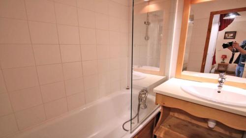uma pessoa a tirar uma foto de uma casa de banho com banheira e lavatório em Résidence Dame Blanche - 2 Pièces pour 6 Personnes 034 em Narreyroux