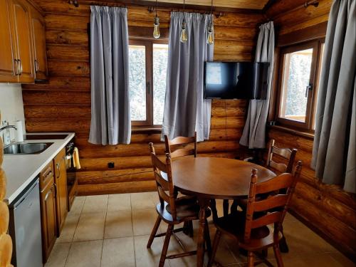uma cozinha com uma mesa e uma televisão numa cabina em къщи за гости Под звездите em Pamporovo