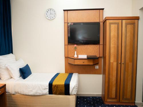 a hotel room with a bed and a tv at Riyadh Al Deafah Hotel in Mecca