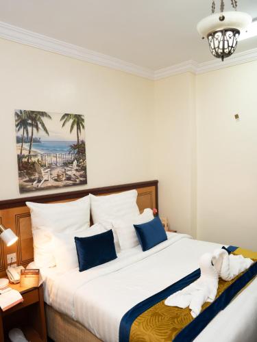 a bedroom with a large bed with blue and white pillows at Riyadh Al Deafah Hotel in Mecca