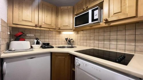 a kitchen with a sink and a microwave at Résidence Dame Blanche - 2 Pièces pour 6 Personnes 074 in Narreyroux