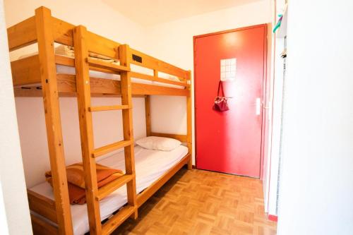 a bedroom with bunk beds with a red door at Résidence Le Cheval Blanc - LE CHEVAL BLANC - CB49 MAE-3114 in Modane