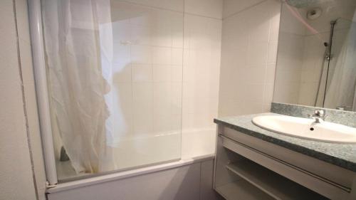une salle de bain blanche avec un lavabo et une douche dans l'établissement Résidence Parc Aux Etoiles - C004PAE - APPARTEMENT 2 CHAMBRES AVEC BALCON MAE-8694, à Narreyroux
