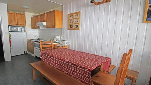 d'une cuisine avec une table et un chiffon rouge. dans l'établissement Résidence Cortina 3 - C3302 - APPT T2 CABINE - BALCON - 6 PERSONNES MAE-8564, à Les Prés