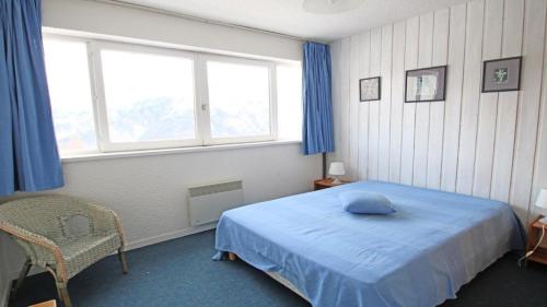 une chambre avec un lit bleu et une fenêtre dans l'établissement Résidence Cortina 3 - C3302 - APPT T2 CABINE - BALCON - 6 PERSONNES MAE-8564, à Les Prés