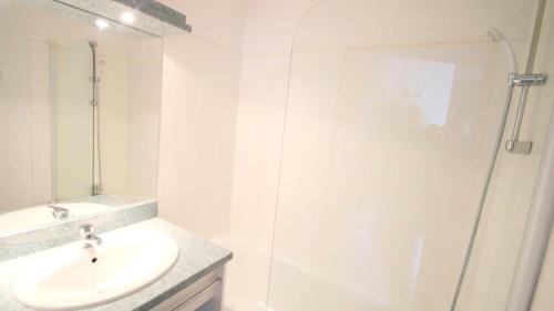 une salle de bain blanche avec lavabo et douche dans l'établissement Résidence Parc Aux Etoiles - C402PAE - APPARTEMENT 2 CHAMBRES AVEC BALCON MAE-8754, à Narreyroux