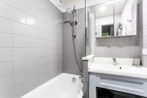 une salle de bain blanche avec une douche et un lavabo dans l'établissement Résidence L'Albane - maeva Home - Appartement moderne 2 pièces 6 personnes - Prestige - super Home MAE-7884, à Vars