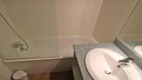 une salle de bain avec un lavabo et une baignoire dans l'établissement Résidence Parc Aux Etoiles - A109PAE - APPARTEMENT SPACIEUX AVEC BALCON MAE-8654, à Narreyroux