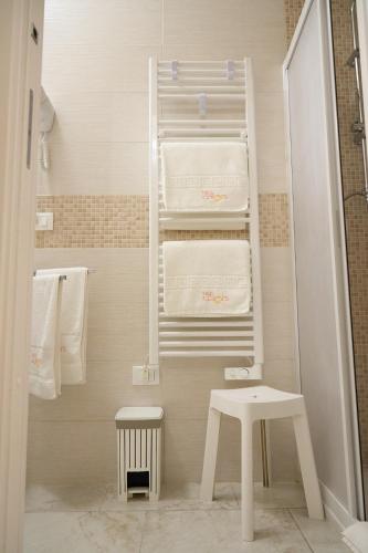a small bathroom with white towels and a stool at B&B Colors in Lesina
