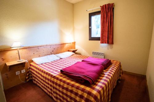 - une chambre avec un lit recouvert d'une couverture violette dans l'établissement Chalets Du Thabor - CHALET DU THABOR - CTHAA231 MAE-3136, à Modane