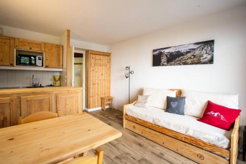 un salon avec un canapé et une table dans l'établissement Résidences quartier Charmettoger - maeva Home - Appartement 2 Pièces 5 Personnes - Sélection MAE-9614, à Arc 1800