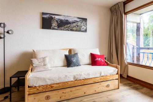 - une chambre avec un lit en bois et des oreillers dans l'établissement Résidences quartier Charmettoger - maeva Home - Appartement 2 Pièces 5 Personnes - Sélection MAE-9614, à Arc 1800
