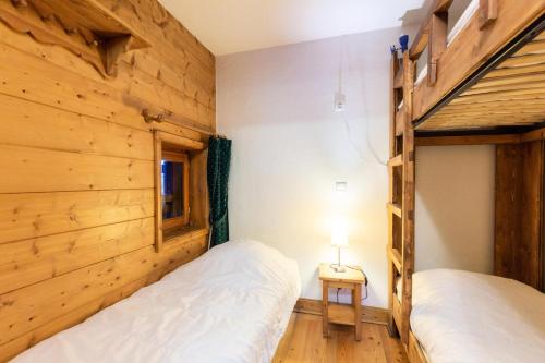 zwei Betten in einem Zimmer mit Holzwänden in der Unterkunft Résidence Les Fermes du Soleil - maeva Home - Appartement 3 pièces 5 personnes - Sélection MAE-9504 in Les Carroz d'Araches