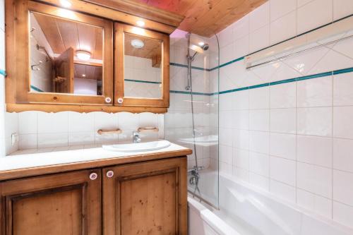 uma casa de banho com um lavatório e um chuveiro em Résidence Les Fermes du Soleil - maeva Home - Appartement 3 pièces 5 perso 504 em Les Carroz d'Araches