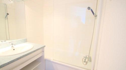 un bagno bianco con lavandino e doccia di Résidence Parc Aux Etoiles - C302PAE - APPARTEMENT 2 CHAMBRES AVEC BALCON MAE-8834 a Narreyroux