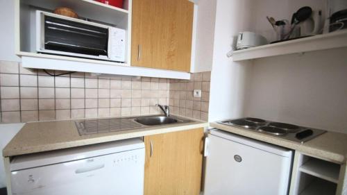 une cuisine avec un évier et un micro-ondes dans l'établissement Résidence Parc Aux Etoiles - C105PAE - APPARTEMENT SPACIEUX AVEC BALCON MAE-8764, à Narreyroux