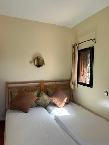 two twin beds in a room with a window at Gite & Camping route Ouarzazate in Chouiter