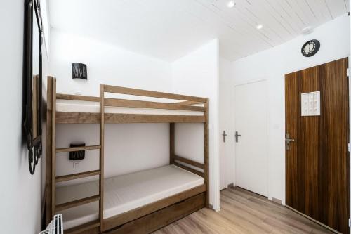 Cette chambre comprend 2 lits superposés et une porte. dans l'établissement Résidence Le Christiana - maeva Home - Appartement 2 pièces 6 personnes - Prestige MAE-8614, à Orcières