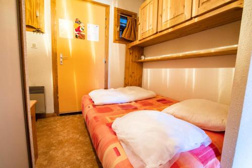 two beds in a small room with wooden cabinets at Résidence Le Grand Vallon - Studio pour 4 Personnes 193157 in Villarodin-Bourget