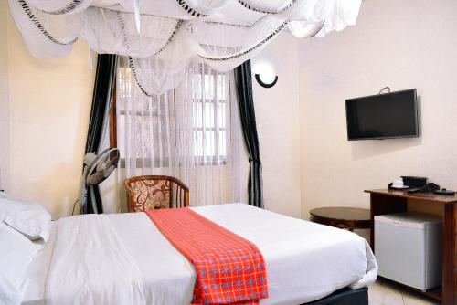 3 Degrees Hotel في أروشا: غرفة نوم بسرير ونافذة مع ستائر