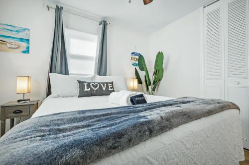 a bedroom with a white bed with a blue blanket at Ixora16 Heated Pool, mins to beach, airport, USSSA, Cruise Port, 1h to Disney in Melbourne