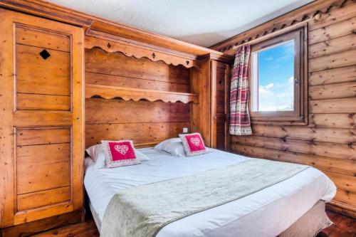 une chambre avec un lit dans une cabane en rondins dans l'établissement Résidence La Ginabelle - maeva Home - Appartement 4 Pièces 8 Personnes - Sélection MAE-7444, à Chamonix-Mont-Blanc