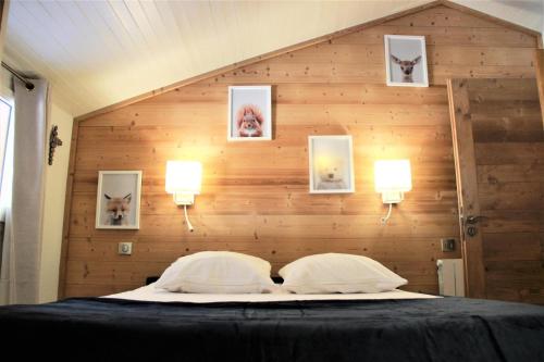 a bedroom with a large bed with a wooden wall at BOURG MOREL G - Duplex Le Bourg Morel 3 - 1 pour 8 Personnes 26 in Valmorel