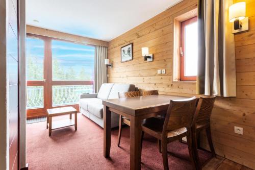 un salon avec une table et un canapé dans l'établissement Résidences quartier Charmettoger - maeva Home - Studio 4 personnes - Sélection MAE-7494, à Arc 1800