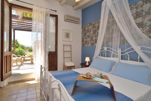 - une chambre avec un lit aux murs bleus et une fenêtre dans l'établissement Villa Giannina, à Ispica