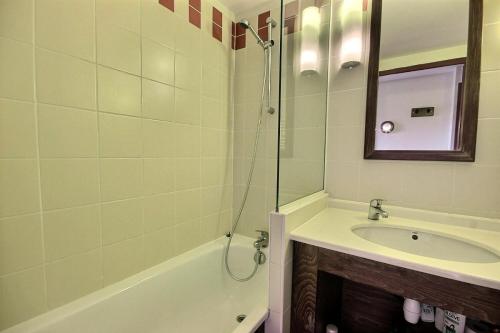 une salle de bain avec une baignoire, un lavabo et un miroir dans l'établissement Résidences quartier Charmettoger - maeva Home - Studio 4 personnes - Sélection MAE-7494, à Arc 1800