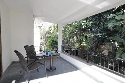 a patio with two chairs and a table on a balcony at The Riverview Retreat Corbett by Leisure Hotels in Garjia