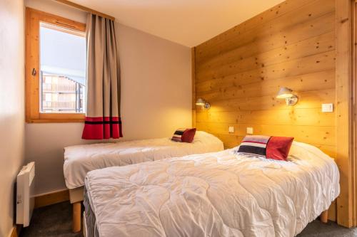 une chambre avec deux lits et une fenêtre dans l'établissement Résidence Les Néreïdes - maeva Home - Appartement 3 pièces 7 personnes - Prestige MAE-2704, à La Plagne Tarentaise