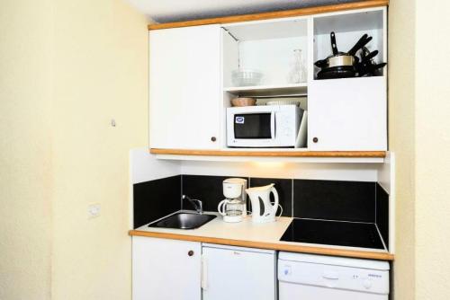 a kitchen with a sink and a microwave at Résidence Quartier Falaise - maeva Home - Appartement 2 pièces 6 personnes - Sélection MAE-2824 in Avoriaz