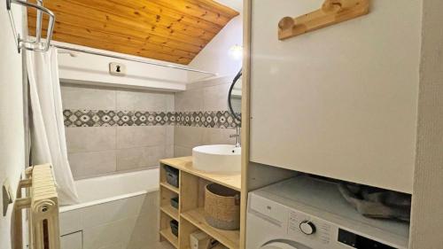 a bathroom with a sink and a tub and a toilet at Le Chalet - Appartements pour 6 Personnes 104 in Puy-Saint-Vincent