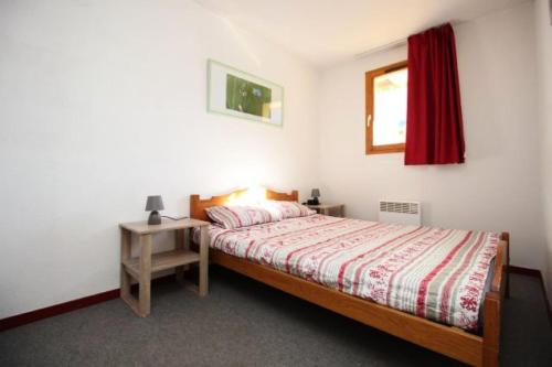 - une chambre avec un lit et une table avec une fenêtre dans l'établissement Résidence Le Cheval Blanc - 2 Pièces pour 6 Personnes 193182, à Modane